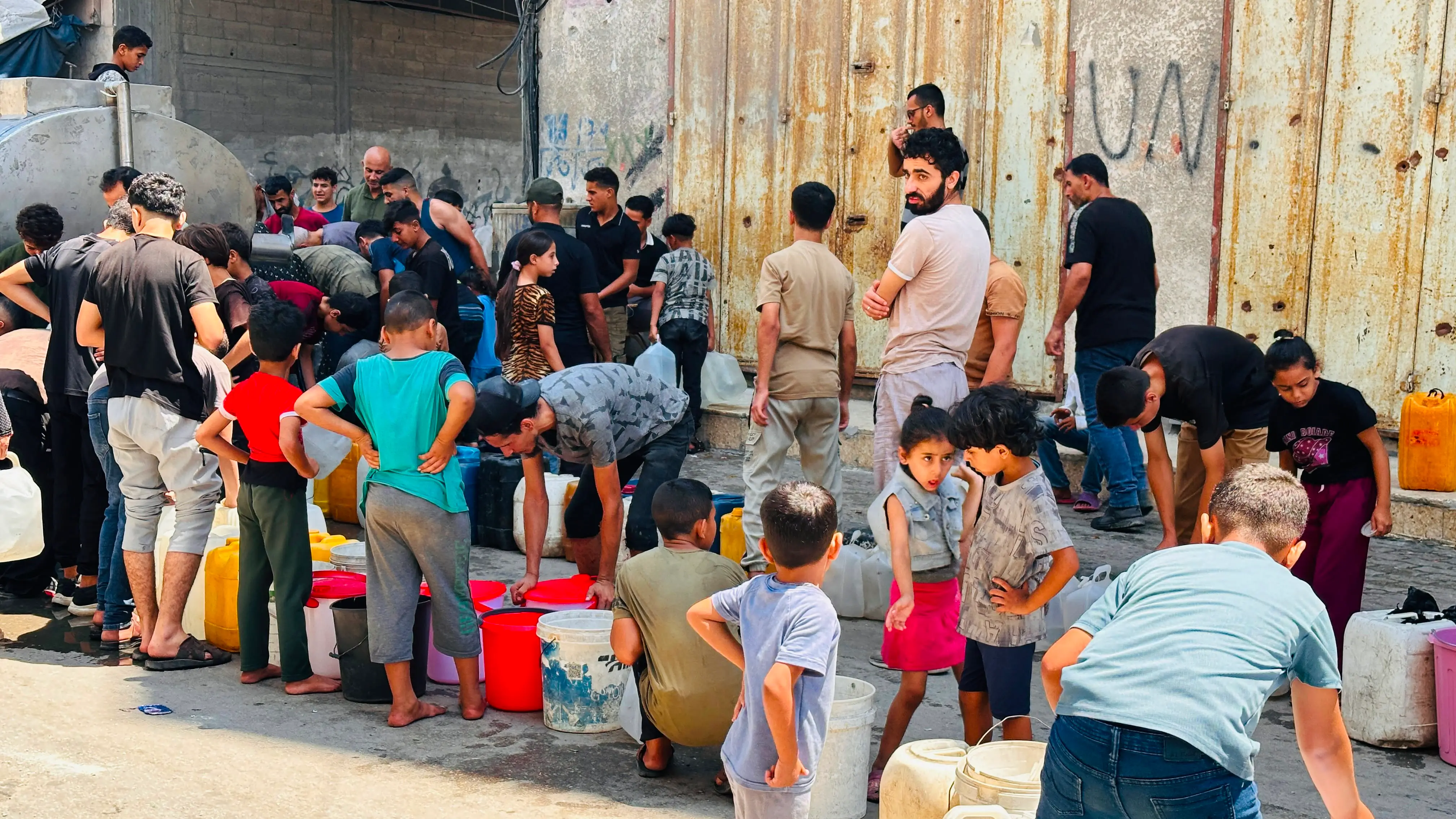 Volunteers distributing clean water to a displaced family